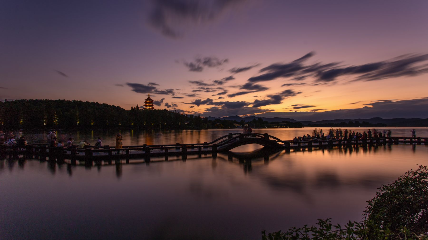 West Lake at sunset, with Leifeng Pagoda and warm reflections across the water in Hangzhou